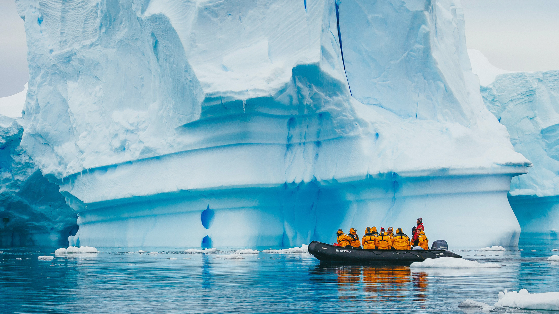 Zodiac con un grupo de personas junto al gran iceberg
